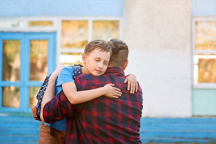Parent hugging a child with eyes closed, showing a tender moment of connection - reflecting compassion in action in Buddhist parenting.