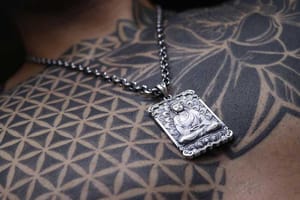 A man wearing a necklace with pendant of Amitabha Buddha