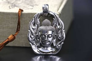 A silver pendant depicting The Buddha engulfed in flames (the flames of awareness)