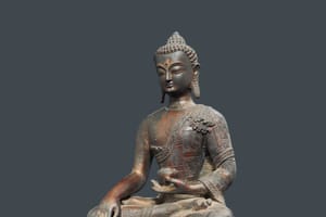 Ancient bronze Buddha statue seated in meditation with detailed robes and serene expression. It symbolizes inner peace, wisdom, and the path to enlightenment.